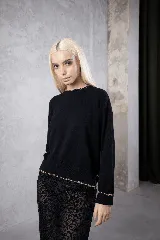 Sweater negro de cuello redondo con detalles de costura artesanal a contratono en el cuello, puños y ruedo. Presenta un corte clásico y ajuste cómodo.