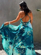 Vestido largo verde con diseño estampado tipo tie-dye y detalles dorados, de corte fluido, un solo hombro y diseño amplio.