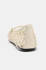 Zapato plano tipo bailarina color crema, con diseño trenzado calado en todo el cuerpo y punta redonda. Posee una delgada tira con hebilla metálica dorada sobre el empeine.