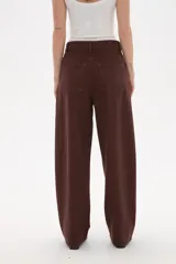 Pantalon jean de corte barrel y tiro medio, en color negro, con diseño de pierna ancha y estructura rígida.