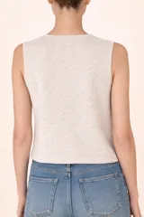 Chaleco de punto sin mangas en color off-white, con cuello redondo y cierre frontal mediante botones decorativos con acabado perlado.