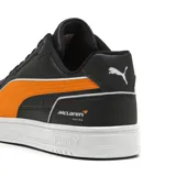 Championes urbanos Puma Caven III edición especial McLaren Racing, color negro con detalles en naranja y suela blanca. Presentan el logo de la marca en el lateral y el emblema de McLaren Racing en el talón.