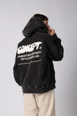 Buzo canguro oversize de algodón frisa premium con efecto lavado en color negro. Presenta capucha, bolsillo frontal tipo canguro y estampa blanca en el pecho.