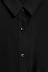 Camisa negra de lyocell con cuello solapa, manga corta y bajo asimétrico. Cierre frontal con botones.