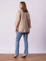 Camisola color beige de tencel, marca Hester & Orchard. Tiene cuello con solapa, escote en V, abertura central con botones y bolsillos delanteros.