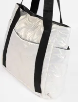 Bolso tipo totebag color negro metalizado, con asas de hombro y bolsillos laterales.