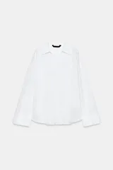 Camisa blanca de la colección ZARA Woman, confeccionada en hilatura con lino, con escote en pico, manga larga con puño ancho y detalles desflecados en cuello y bajo.