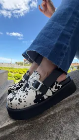 Zueco cerrado 100% de cuero color tostado con efecto desgastado, detalles en cuero negro y una tira con hebilla metálica decorativa.