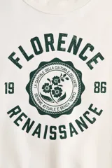 Buzo de corte oversized con cuello redondo, mangas largas de hombros caídos y puños acanalados. Presenta un diseño estampado frontal con la inscripción Florence Renaissance y un motivo floral central.