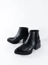 Botas cortas negras de cuero con cierre lateral y elástico en los laterales. Taco cuadrado y plataforma.
