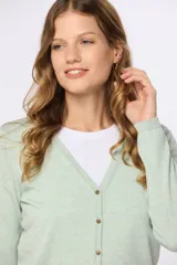 Saco tejido fino de hilo de algodón color beige, con cuello en V, cierre frontal con botones y puños acanalados.