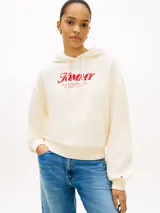 Buzo con capucha Tommy Hilfiger de color blanco, confeccionado en felpa de puro algodón. Presenta un corte amplio con hombros caídos, puños y bajo de punto canalé, y cordón ajustable en la capucha. En el pecho destaca un logotipo texturizado en tono rojo, complementado con un pequeño logo bordado en el puño.