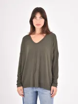 Remera de manga larga color verde oliva, con cuello en V y diseño holgado con caída fluida.