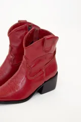 Bota de caña media baja realizada en cuero engrasado color negro, con detalle de punta fina y taco de 5 cm. El interior está forrado en forrería vacuna y el fondo es de madera.