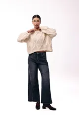 Sweater de tejido de punto grueso con diseño de rombos en relieve, cuello redondo y mangas largas amplias. Presenta una silueta relajada y holgada.