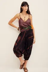 Pantalón babucha de algodón con estampa batik en tonos marrones y negros, tiro bajo y diseño amplio con puños elastizados en los tobillos.