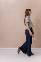 Jean de calce amplio y relajado, color azul, con pierna extra ancha y caída fluida. Diseño de tiro alto con pinzas delanteras y lazo regulable en la cintura. Cuenta con bolsillos laterales y traseros.