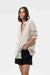 Camisa Riva de lino color beige, de calce relajado y silueta ligeramente oversized, con solapa y cierre frontal de botones.