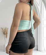 Top amarillo pálido con cuello halter y escote profundo. Se puede usar de múltiples formas.