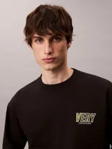 Buzo Calvin Klein de felpa color negro, con cuello redondo, manga larga, puños y dobladillo acanalados. Presenta un bordado frontal con la palabra "VERY" en tonos verdosos y debajo el logo de la marca.