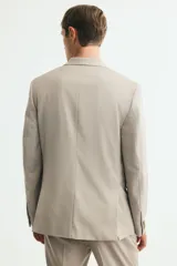 Blazer slim fit de botonadura sencilla en color beige, con solapas de muesca, bolsillos con solapa y cierre de botones.
