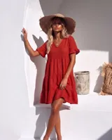 Vestido corto color azul de lino, con escote en V, mangas cortas con volados y diseño escalonado en la falda.