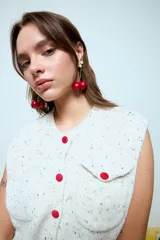 Caravanas colgantes con diseño de cerezas rojas y detalle de perla blanca en la parte superior.