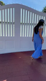 Mono largo de lino color beige, con breteles finos ajustables que se atan en la espalda, corte holgado y bolsillos laterales.