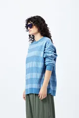 Sweater tejido en jacquard con diseño de franjas geométricas horizontales en tonos beige y blanco.