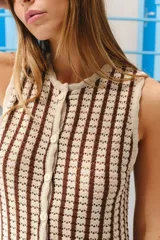 Chaleco tejido de punto con rayas verticales en tonos beige y marrón, sin mangas, con cierre frontal de botones.