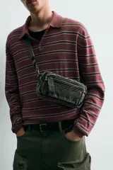 Bandolera de tejido denim con efecto lavado, cuenta con compartimento principal con cierre de cremallera, bolsillo interior con cierre y asa de hombro ajustable.