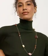 Conjunto de bisutería compuesto por un maxi collar largo de cadena fina con piedras asimétricas en tonos tierra y un par de aros tipo botón redondeados con acabado dorado.