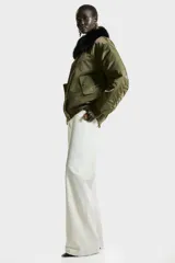 Jean de tiro alto con corte wide leg, confeccionado en denim rígido de color blanco. Presenta diseño clásico de cinco bolsillos, cierre frontal con botón y ruedo con terminación desflecada.