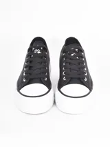 Zapatillas de plataforma estilo urbano, color negro con puntera y suela de goma blanca. Cuentan con cordones negros y ojales metálicos.