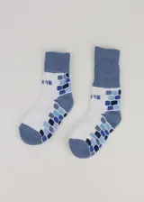 Medias blancas con puño doble tejido super grueso color celeste, diseño de bloques azules y texto ilegible.