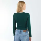 Camiseta cropped de manga larga color verde oscuro, con cuello redondo.