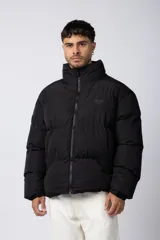 Campera puffer negra con diseño inflado, cuello alto y cierre frontal completo. Presenta logo bordado sutil en el pecho y puños ajustados.