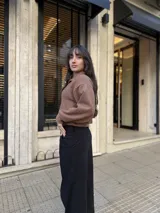 Buzo de punto color marrón, con cuello polo abierto y diseño corto de corte holgado.