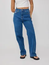 Jean recto de mezclilla azul medio, tiro alto, con un calce holgado y pierna ancha.