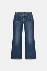 Jeans de tiro bajo y corte flare, confeccionados en denim azul con lavado localizado. Presentan bolsillos de plastrón en el delantero, trabillas para cinturón y cierre frontal con cremallera y doble botón metálico.