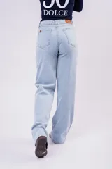 Pantalón de jean corte wide leg en color celeste claro, con tiro medio y diseño de pierna ancha. Presenta cierre frontal con botón y bolsillos laterales.