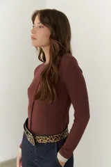 Remera color beige de mangas largas con cuello redondo y puños blancos en contraste.