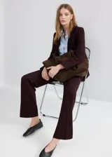Pantalón de corte recto y tiro medio con diseño largo, trabillas para cinturón, dos bolsillos laterales y cierre oculto con botón, gancho y cremallera.