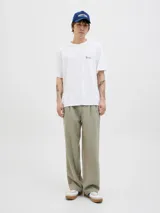 Remera de corte holgado color blanco, con cuello redondo y manga corta. Presenta una estampa artística en la espalda con motivos de playa, sombrilla y silla de descanso.