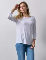 Remera blanca de modal con cuello cuadrado y aplique de aros metálicos.