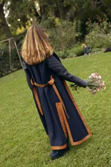 Abrigo largo tipo bata con cuerpo de tweed marrón, mangas acolchadas capitonadas y solapa de corderito. Presenta detalles de vivos en cuero, cinturón de cuero para ajustar a la cintura y aberturas laterales profundas.