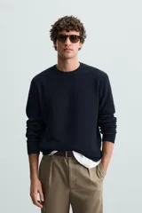 Sweater de punto color beige con textura tipo waffle, cuello redondo y mangas largas con acabado en rib.
