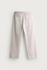 Pantalón de corte relajado confeccionado en una mezcla de algodón y lino. Presenta cintura elástica con cordón ajustable, bolsillos laterales y bolsillos traseros de vivo.