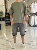 Remera oversize de tejido texturizado en color verde militar, con cuello redondo y mangas cortas. Presenta un pequeño bordado blanco en el pecho.