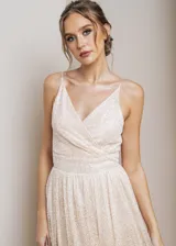 Vestido largo de fiesta con escote en V cruzado y breteles finos. Confeccionado en tela con acabado brillante y falda con caída fluida.